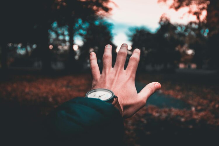 person wearing round analog watch